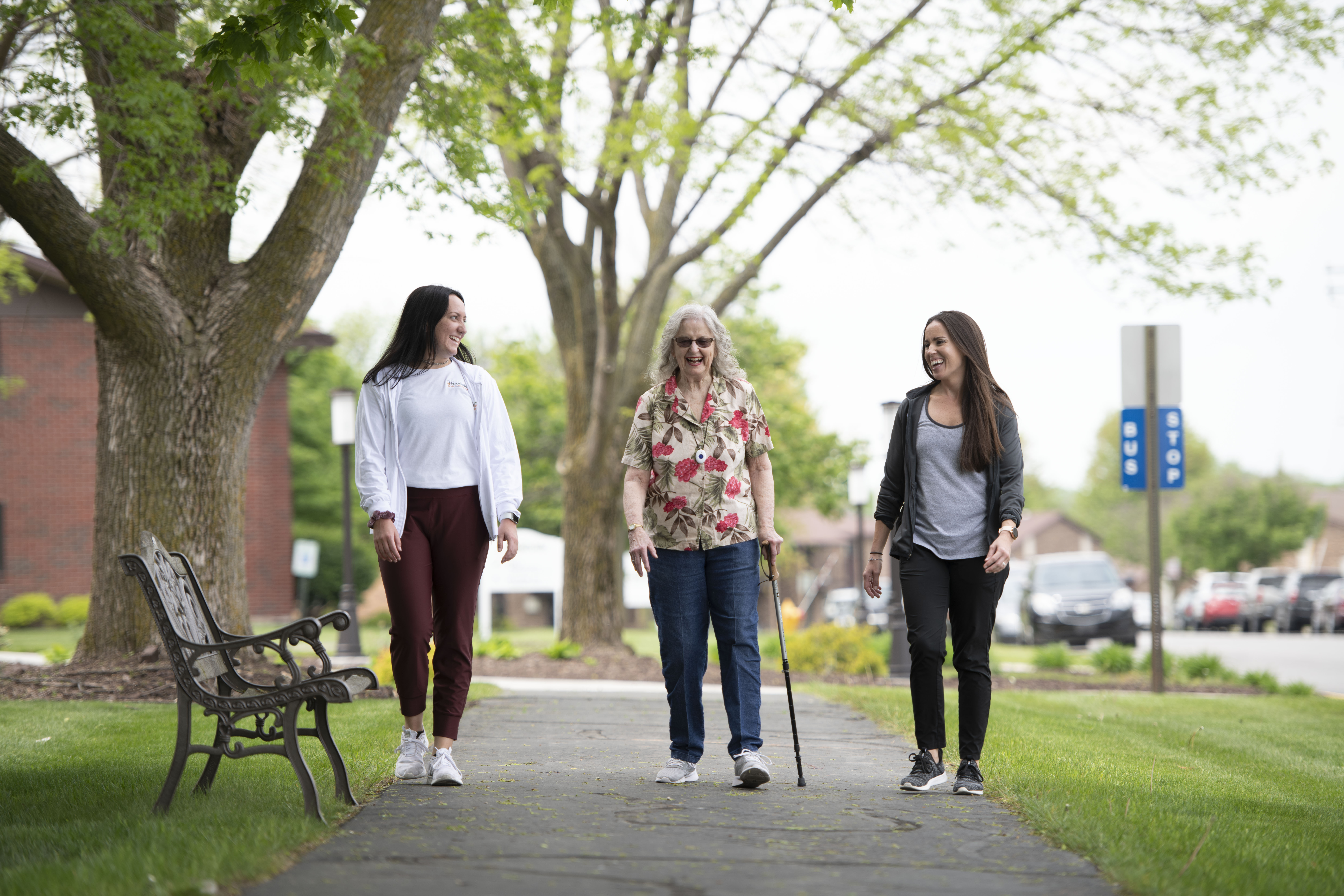 Resident walking with Wellness Services team members.